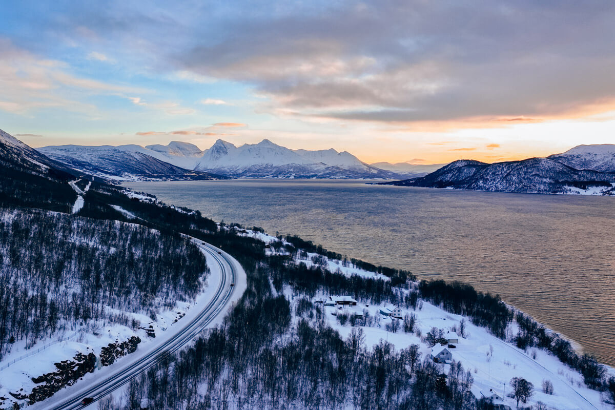 aerial shot of a scenic road in Norway leading through mountains and fjords